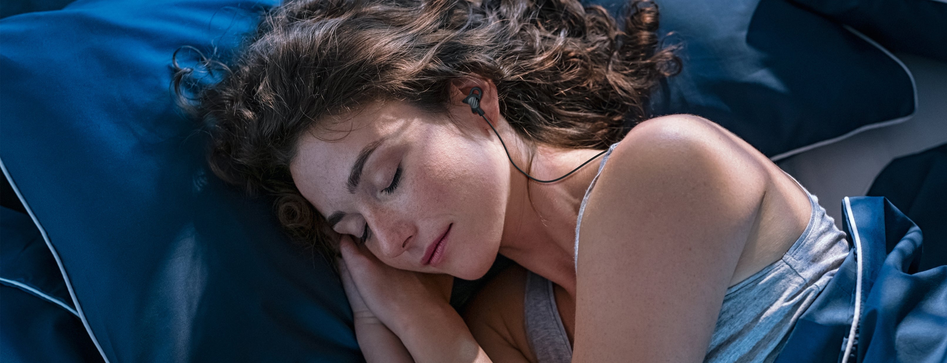 Person sleeping while wearing SleepTones ultra compact silicone sleeping earbuds